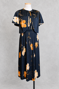 Robe vintage mi-longue avec bolero noire à motifs floraux orange et écru – col rond, jupe plissée