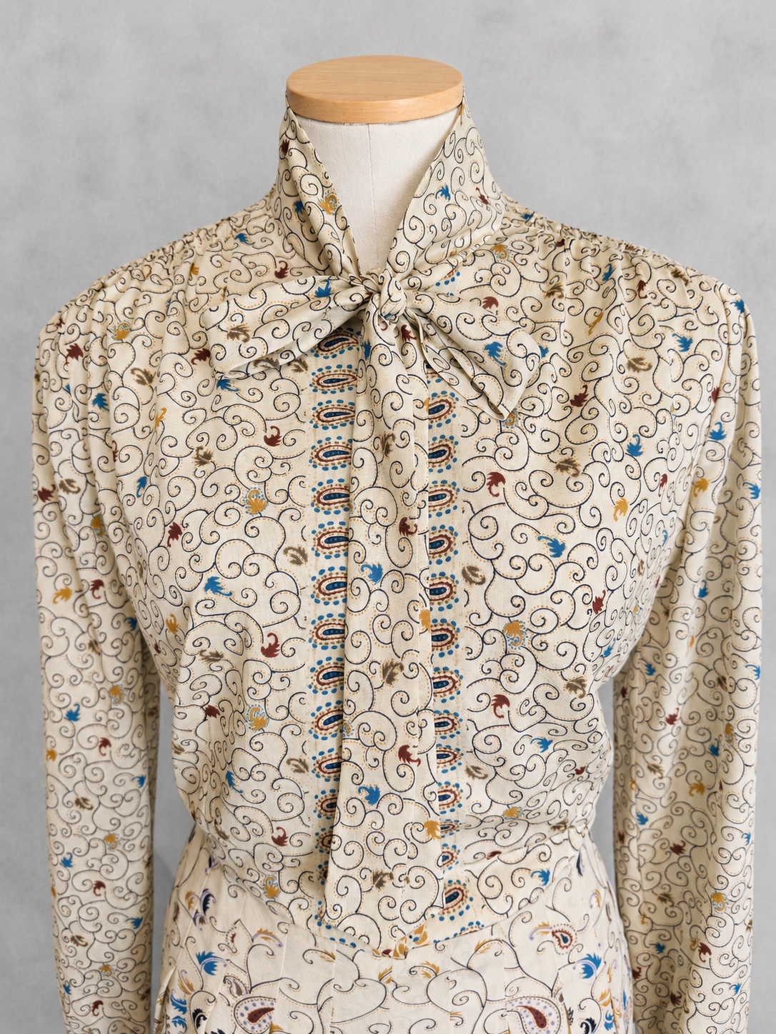 Robe vintage mi-longue écrue à motifs paisley bleu et marron – col lavallière, manches longues