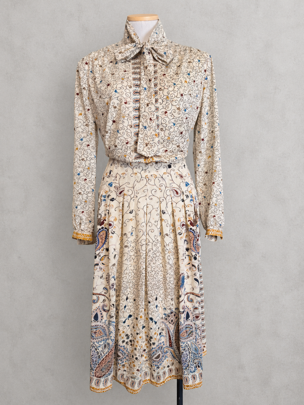 Robe vintage mi-longue écrue à motifs paisley bleu et marron – col lavallière, manches longues
