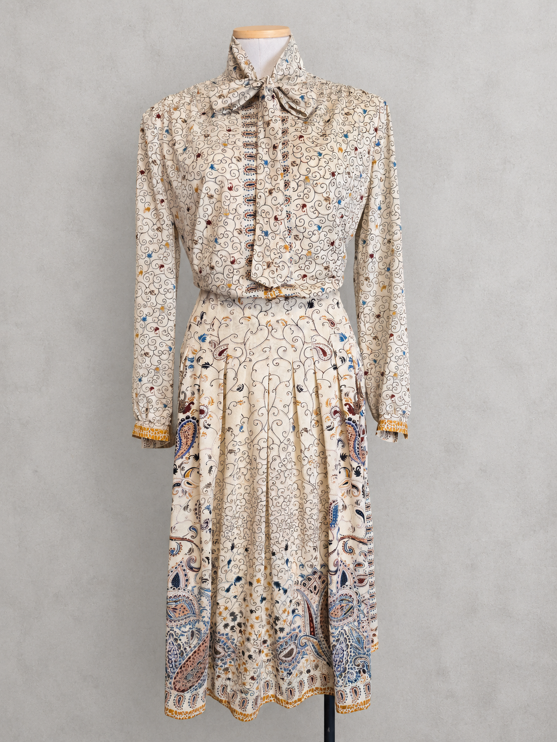 Robe vintage mi-longue écrue à motifs paisley bleu et marron – col lavallière, manches longues